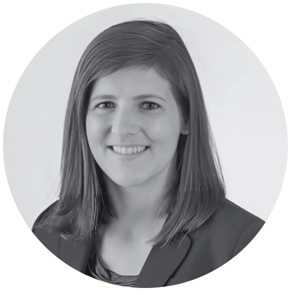 A circular image of a young adult woman with brown shoulder length hair sitting for a professional headshot