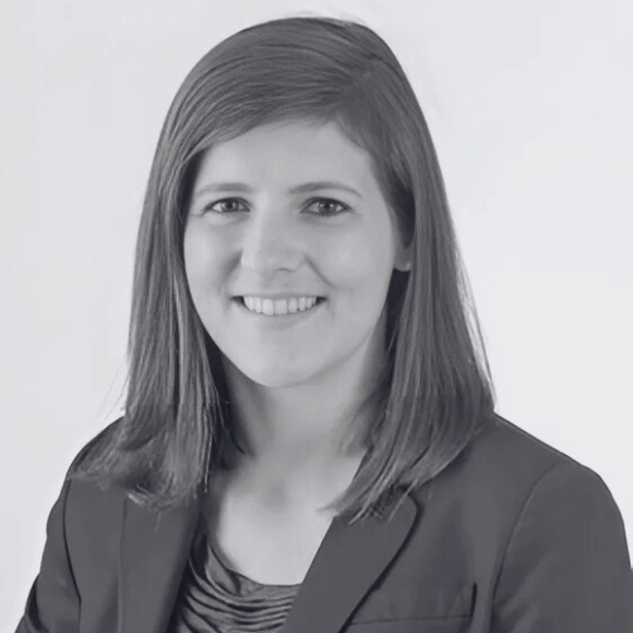 An image of a young adult woman with brown shoulder length hair sitting for a professional headshot