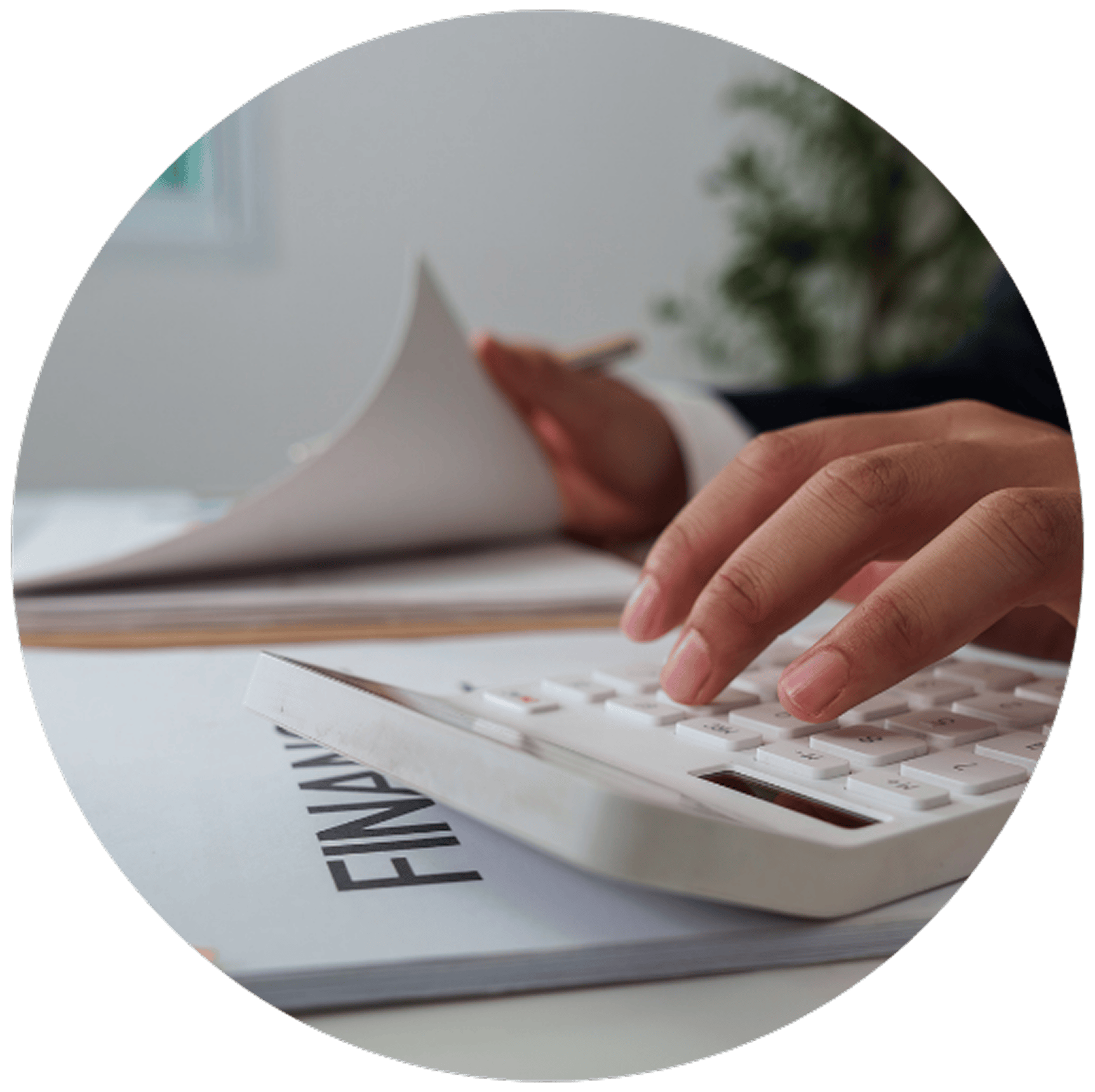 Close-up of hands using a calculator and flipping through financial documents on a desk, suggesting focus and diligence in financial planning.