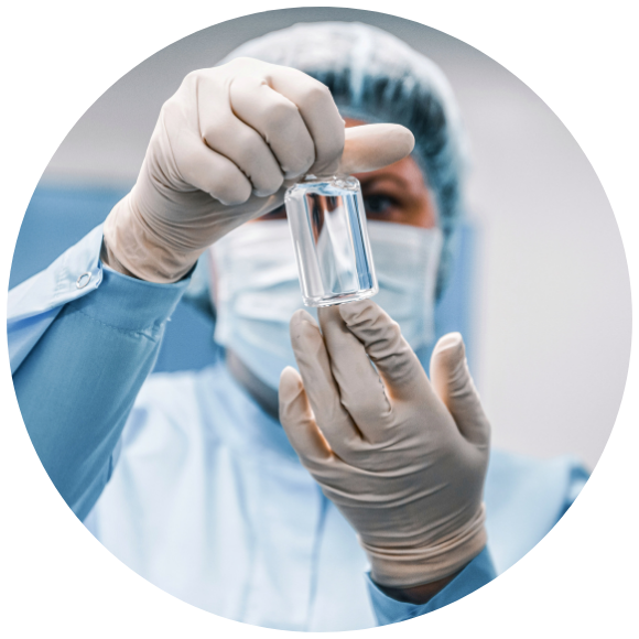 A scientist in protective gear examines a clear vial in a lab, conveying precision and focus.