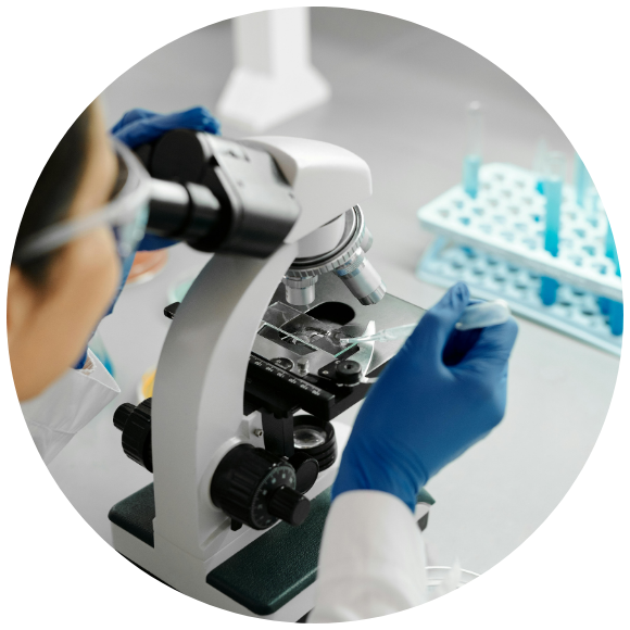 Scientist using a microscope to examine samples during medical research.