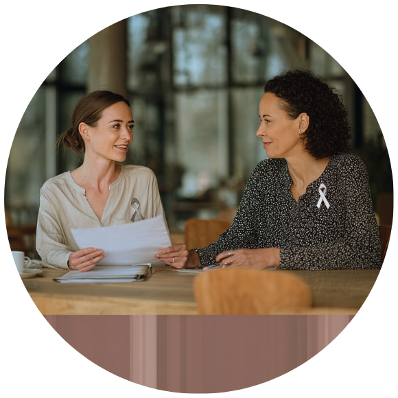 Two women reviewing medical documents together during a care discussion.