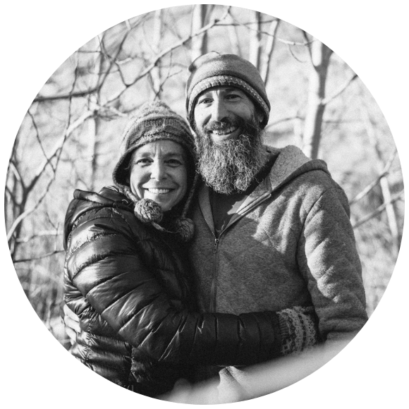 Couple standing together outdoors in winter clothing, sharing a close embrace.