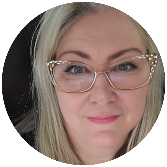 Close-up portrait of an adult woman wearing glasses, looking directly at the camera.