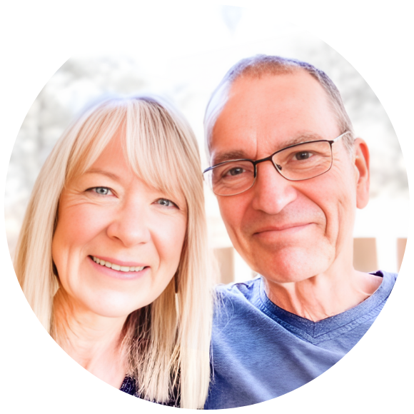 Couple smiling together outdoors in a close, supportive portrait.
