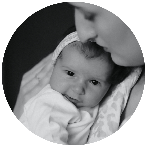Infant resting in a caregiver’s arms in a quiet, close moment.