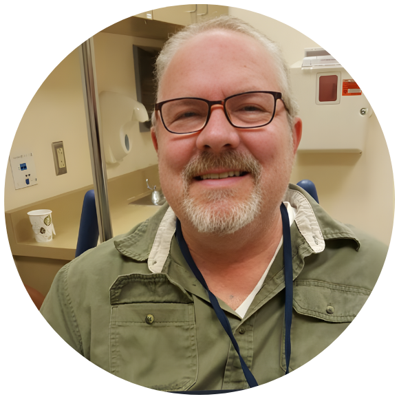 Adult man smiling in a medical exam room during an appointment.