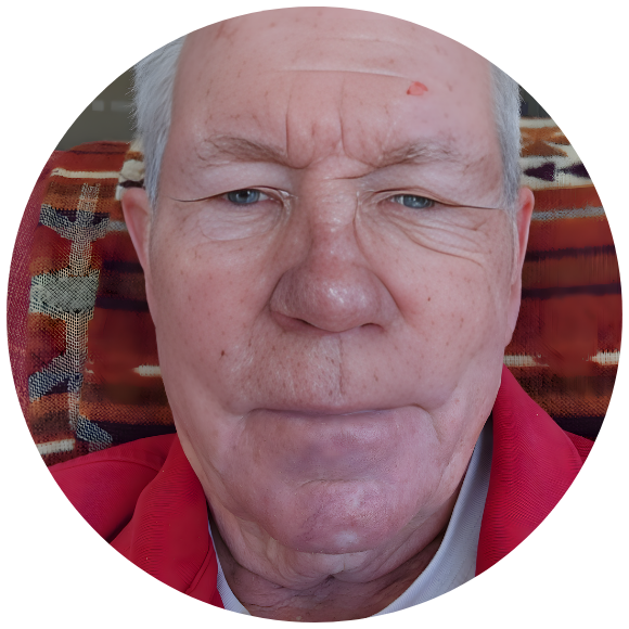 Older adult seated at home, looking directly at the camera.