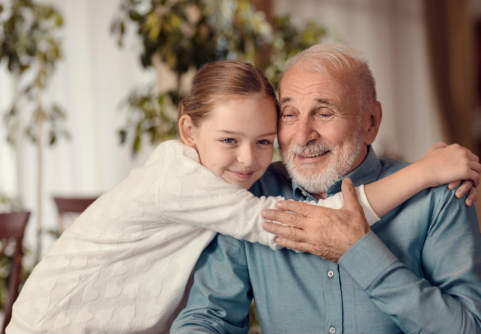 Young child hugging an older adult in a warm, supportive moment at home.