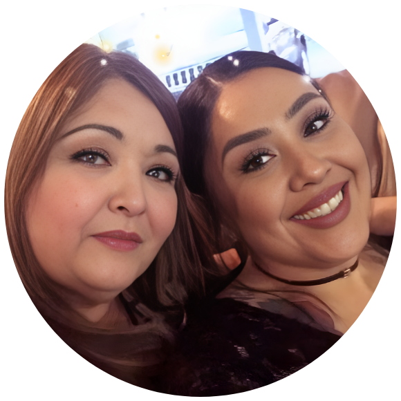 Two women smiling together in a close, supportive portrait.