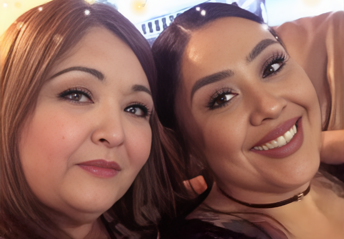 Two women smiling together in a close, supportive portrait.