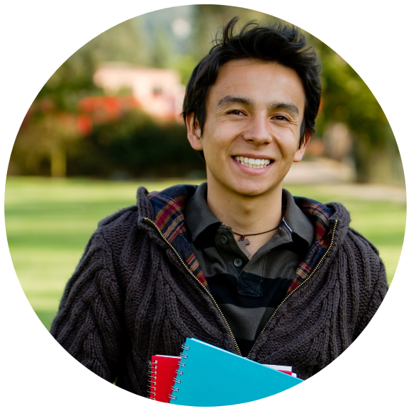Young adult smiling outdoors in a park setting.