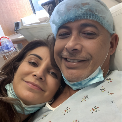 Patient in a hospital bed smiling with a loved one before a medical procedure.