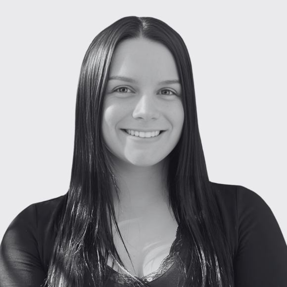 a square headshot of a young female professional smiling at the camera with long dark hair