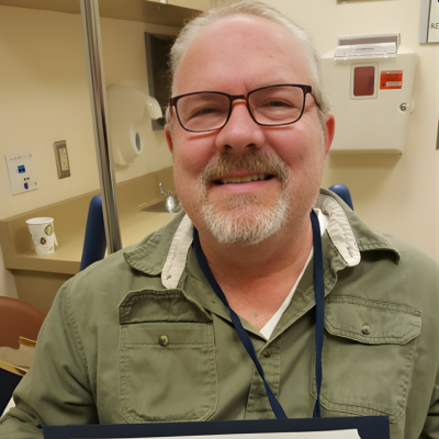 Adult man smiling in a medical exam room during an appointment.
