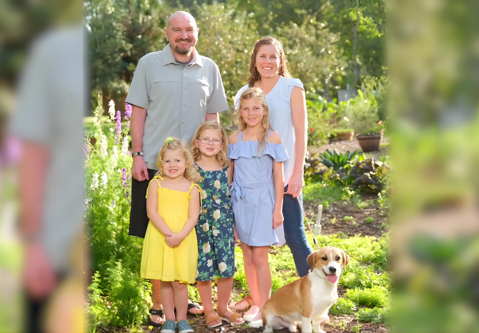 A family stands outside together smiling for a group photo